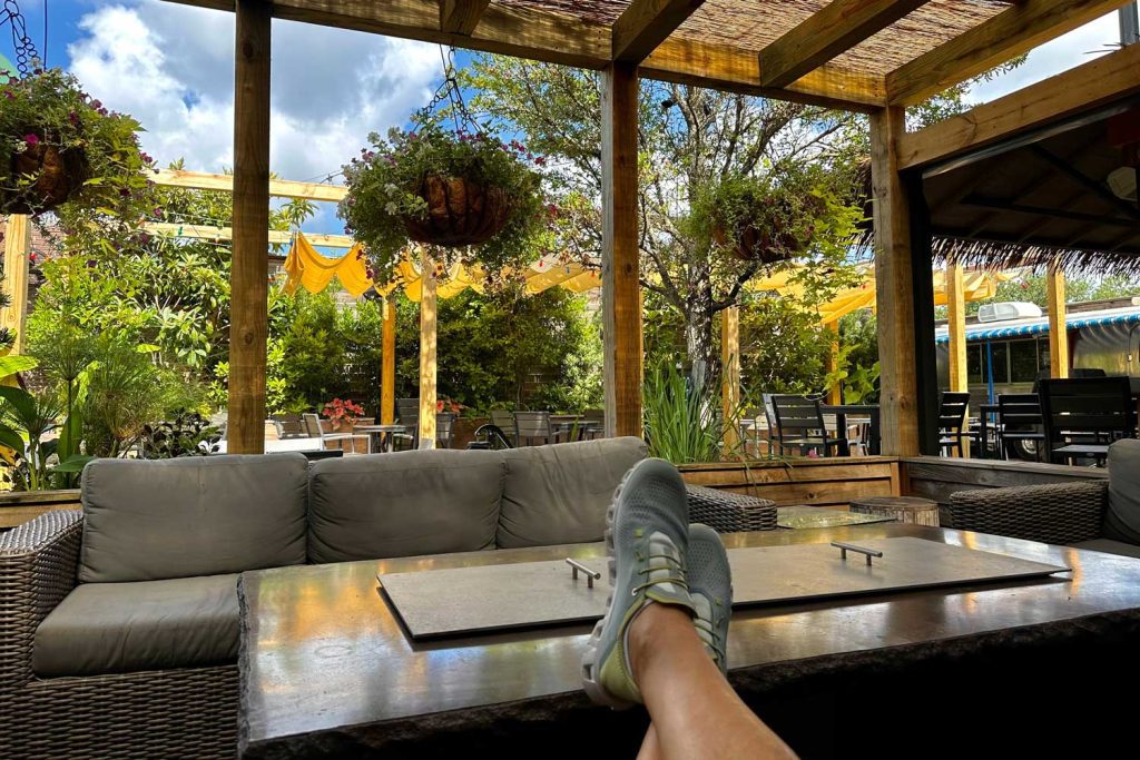 A wide view of the Mahogany Bar Patio with feet propped on the fire pit ledge.